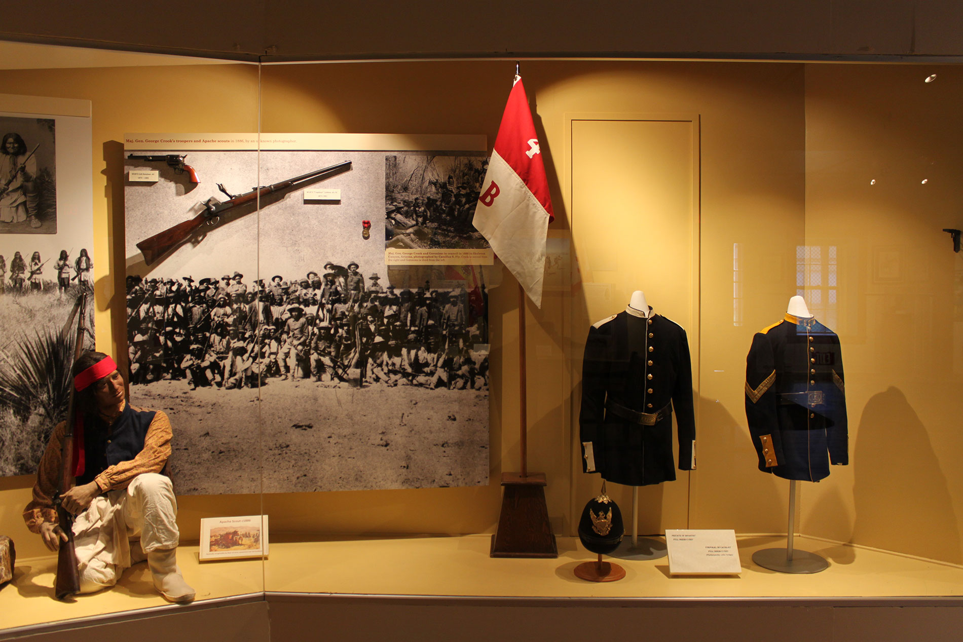 Corner museum display with several artifacts inside glass enclosure_D.